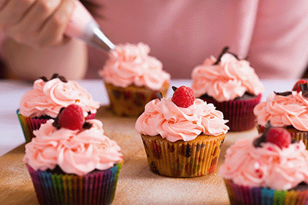 hands decorating cupcakes